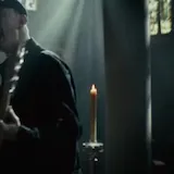 Musician performs live in candlelit church at 0:24