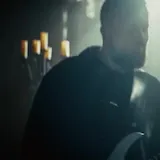 Musician performs live in candlelit church at 0:08