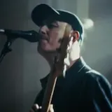 Musician performs live in candlelit church at 0:01