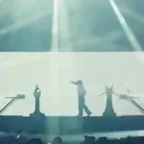 Concert stage lights over silhouetted performer at 0:01