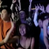 Blue-lit concert stage with crowd silhouettes at 0:09