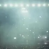 Dark wide shots of Madeon's live stage and crowd at 0:01