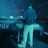 DJ performs on stage with text overlay at 0:01