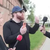 Street interview cut with flags and portrait b-roll at 0:01