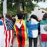 Street interview cut with flags and portrait b-roll at 0:18