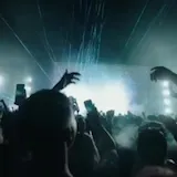 DJ plays live set under teal lasers at 1:56