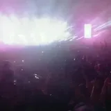 DJ plays live set under teal lasers at 1:17