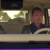 Men in a purple G-Wagon spot a rhino mascot driving a golf cart at 0:01