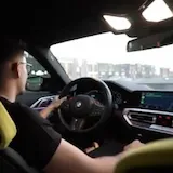 Hombre conduciendo un BMW mientras conversa at 0:15