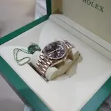 Rolex watch in open green box at 0:01