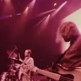 Band performing live on a concert stage at 0:14