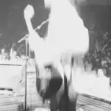 Black-and-white live band crowd footage at 0:03
