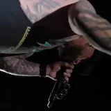 Live concert performance of tattooed singer at 0:55