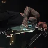 Live concert performance of tattooed singer at 0:18