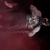 Live concert guitar performance on dark red stage at 1:04