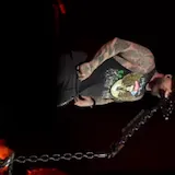 Live concert guitar performance on dark red stage at 0:01
