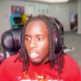 Kai Cenat reacting in gaming chair on stream at 0:01