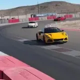 Handheld footage of cars on desert race track at 0:29