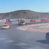 Handheld footage of cars on desert race track at 0:19