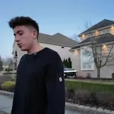 Man walks past mansion and supercars at 0:03