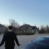 Man walks past mansion and supercars at 0:06