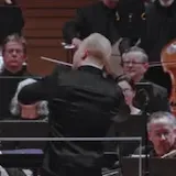 The camera pans over her bow and strings as she performs at 0:12