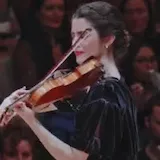 The camera pans over her bow and strings as she performs at 0:01