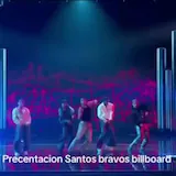 Santos Bravos perform on a neon-lit Billboard stage as five dancers move at 0:20