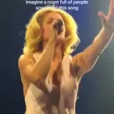 Ashe sings live on tour stage at 0:06