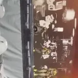 Dancers rehearse a tour number from the side of the stage under amber at 0:41
