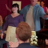 Sitcom scene: man tells crowd to keep joking at 0:10
