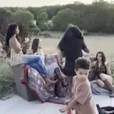 Women in cowboy outfits posing on patio at 0:01