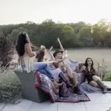Women in cowboy outfits posing on patio at 0:11