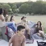 Women in cowboy outfits posing on patio at 0:03