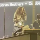 Live stage performance filmed from the crowd at 0:08