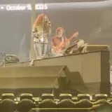 Live stage performance filmed from the crowd at 0:01