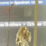 Live stage performance filmed from the crowd at 0:05