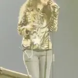 Singer performing live on arena stage at 0:15