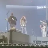 Singer performing live on arena stage at 0:01